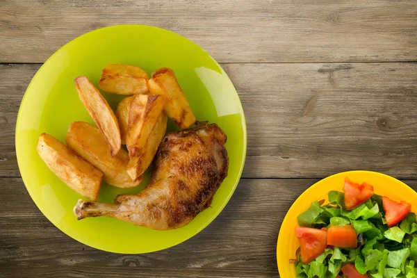 Muslo de pollo con papas fritas sobre fondo de madera . —  Fotos de Stock