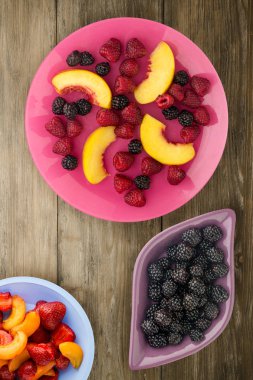 Diyet, sağlıklı gıda. böğürtlen, ahududu, nektarin bir plaka üzerinde bir tabakta. Ahşap arka plan üzerinde Vejetaryen yiyecekler