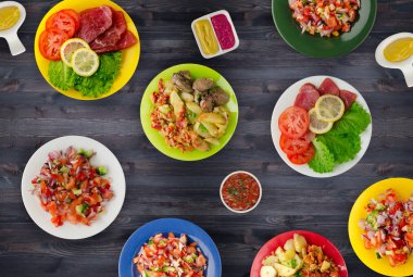 bir tabak üzerinde et yemekleri. bir tabak salata. masada yiyecek bolluk. 