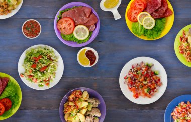 bir tabak üzerinde et yemekleri. bir tabak salata. masada yiyecek bolluk. 