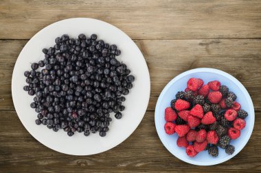 ahşap arka plan üzerinde bir plaka üzerinde yaban mersini. meyve diyeti. vegan gıda