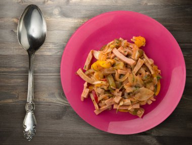 Ahşap arka plan üzerinde bir tabakta Berlin salata. Salata sausa üzerinden