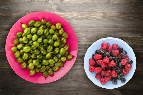 Gooseberries on plate  on wooden background. green gooseberry top view. healthy food — Stock Photo, Image