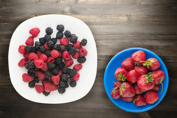 Blackberries and raspberries on a plate. blackberries and raspberries on wooden background. vegetarian food — Stock Photo, Image