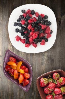 böğürtlen ve ahududu bir plaka üzerinde. böğürtlen ve ahududu ahşap arka plan üzerinde. Vejetaryen gıda