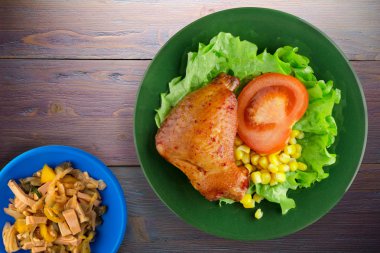 tavuk kanadı salata, Mısır ve domates bir plaka üzerinde 