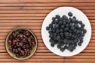 Böğürtlen ahşap arka plan üzerinde bir tabakta. Vejetaryen yiyecekler. Sağlıklı beslenme