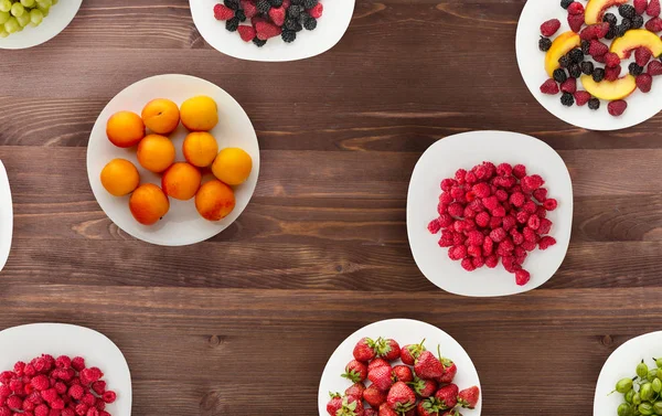 Frutas en un plato. comida vegetariana sobre fondo de madera. veganas f — Foto de Stock