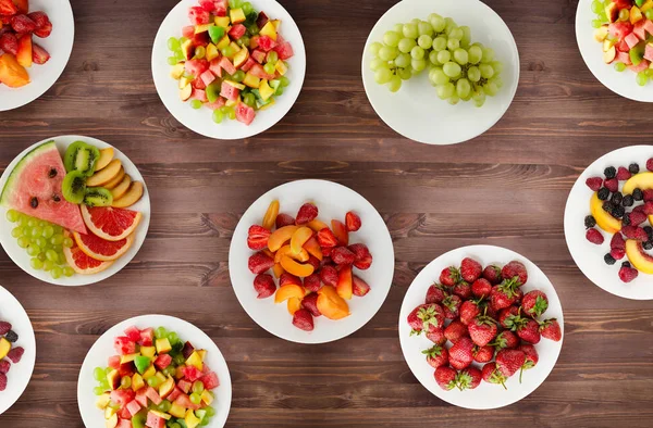 Dieta de frutas. Frutos en un plato sobre un fondo de madera. Alimento saludable — Foto de Stock