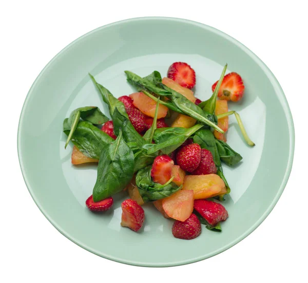 salad with strawberries, pineapple and spinach on a plate. frui