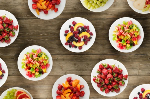 Dieta de frutas. Frutos en un plato sobre un fondo de madera. Saludable fo — Foto de Stock