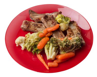 brokoli lahana, havuç ve sarımsak ile ızgara domuz kaburga bir tabakta. beyaz bir arka plan üzerinde sebze ile kızarmış kaburga. doyurucu rustik gıda üst görünümü