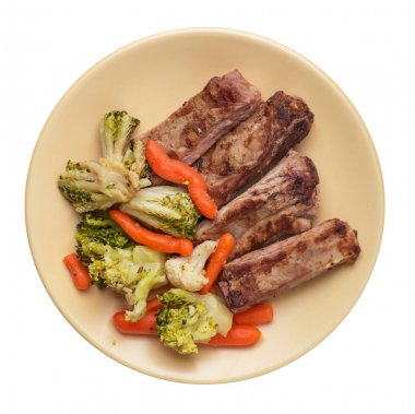 brokoli lahana, havuç ve sarımsak ile ızgara domuz kaburga bir tabakta. beyaz bir arka plan üzerinde sebze ile kızarmış kaburga. doyurucu rustik gıda üst görünümü