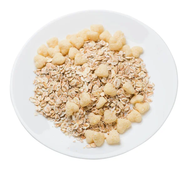 Gesundes Frühstück auf einem Teller isoliert auf weißem Hintergrund. Müsli mit Cornflakes, Rosinen, Datteln, Birnen und Ananas getrockneten Cashewnüssen. — Stockfoto