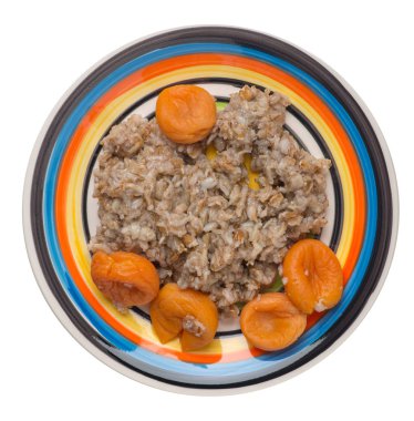 Sağlıklı gıda .rzhanye bir tabaktabakta kuru kayısı ile gevreği. beyaz arka plan üzerinde izole yağmurlu pullar. üst görünüm kahvaltı