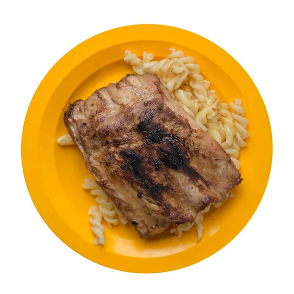grilled pork ribs with pasta. grilled pork ribs on a  plate isol