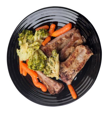 brokoli lahana, havuç ve sarımsak ile ızgara domuz kaburga bir tabakta. beyaz bir arka plan üzerinde sebze ile kızarmış kaburga. doyurucu rustik gıda üst görünümü