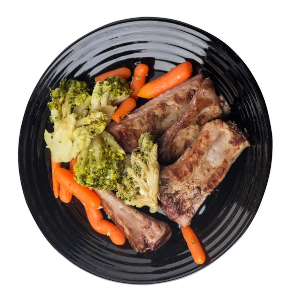 brokoli lahana, havuç ve sarımsak ile ızgara domuz kaburga bir tabakta. beyaz bir arka plan üzerinde sebze ile kızarmış kaburga. doyurucu rustik gıda üst görünümü