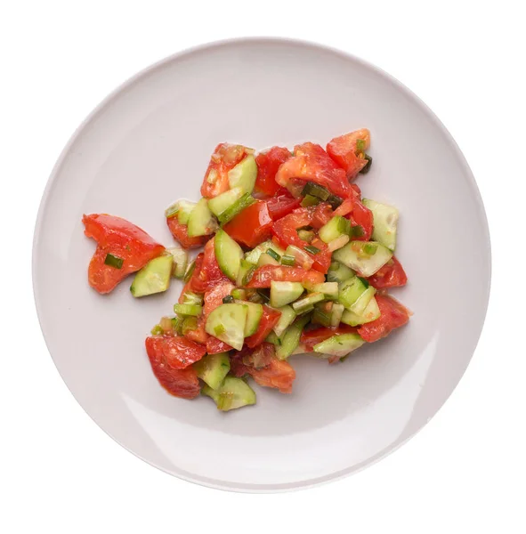 Salade végétarienne aux concombres, tomates et oignons verts .salade végétalienne sur une assiette isolée sur fond blanc. — Photo