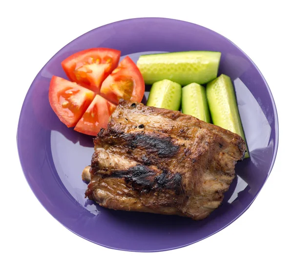 grilled pork ribs with sliced cucumbers and tomatoes on a plate. pork ribs isolated on white background. ribs  top view