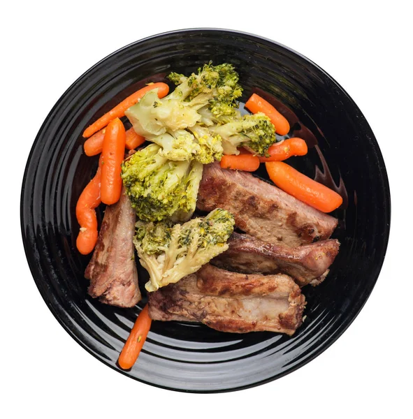 grilled pork ribs with broccoli cabbage, carrots and garlic on a