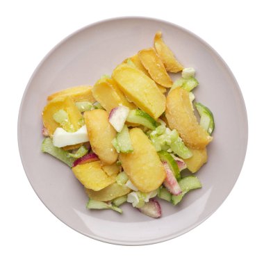 Beyaz arka planda izole bir plaka üzerinde sebze ile patates takozlar. rustik gıda. sebze üst görünümü ile patates.