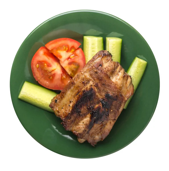 grilled pork ribs with sliced cucumbers and tomatoes on a plate.