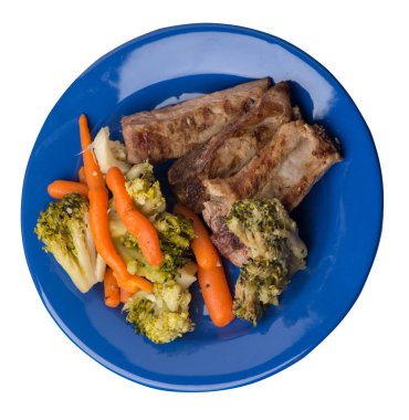 brokoli lahana, havuç ve sarımsak ile ızgara domuz kaburga bir tabakta. beyaz bir arka plan üzerinde sebze ile kızarmış kaburga. doyurucu rustik gıda üst görünümü