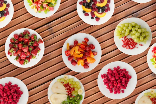 Dieta de frutas. Frutos en un plato sobre un fondo de madera. Saludable fo — Foto de Stock