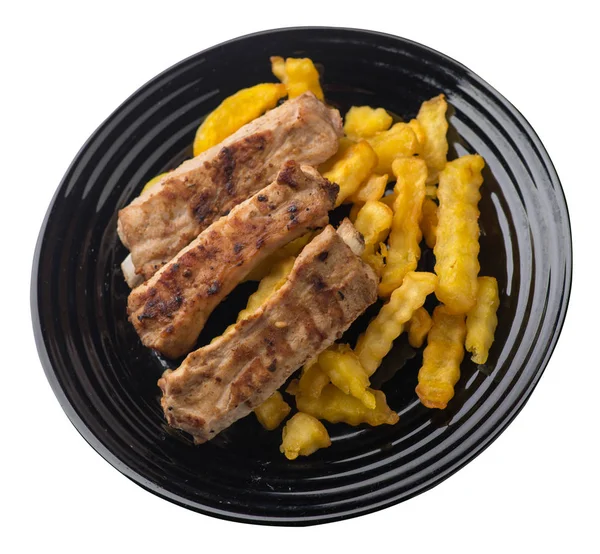 grilled pork ribs with french fries on a  plate. pork ribs with