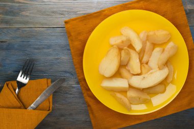 Ahşap bir arka planda, tabakta patates kızartması.