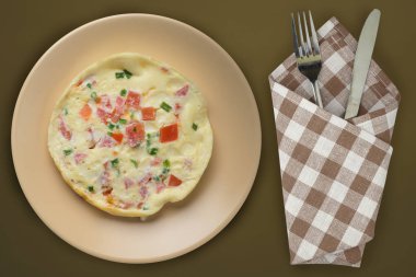  Kahverengi arka planda bej bir tabakta omlet. sağlıklı mola