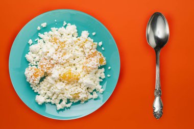 Mavi tabakta şeftalili süzme peynir, turuncu bir sırt.