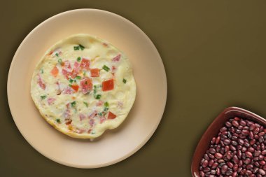  Kahverengi arka planda bej bir tabakta omlet. sağlıklı mola