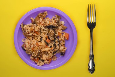 Sarı arka planda mor tabakta pirinç. Beyaz pirinç üstü vi