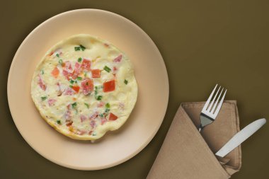  Kahverengi arka planda bej bir tabakta omlet. sağlıklı mola