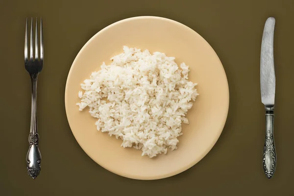 Bílá rýže na béžovém talíři. rýže na hnědém pozadí horní vie — Stock fotografie