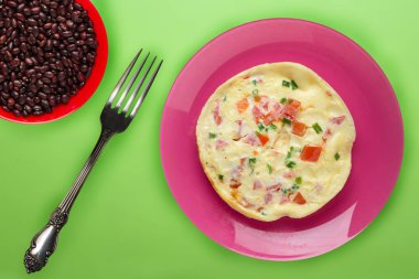 Turuncu arka planda mavi bir tabakta omlet. sağlıklı kahvaltılıklar