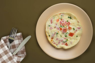  Kahverengi arka planda bej bir tabakta omlet. sağlıklı mola