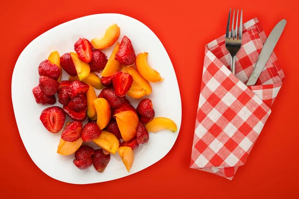 Nourriture saine. Fraises et abricots sur une assiette blanche. frais — Photo