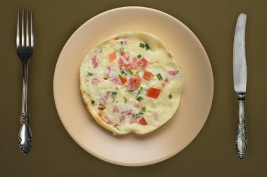  Kahverengi arka planda bej bir tabakta omlet. sağlıklı mola