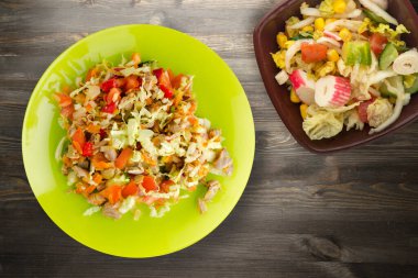 Tavuk mideli salata ile sebze havuç, soğan, biber, lahana, domates, brokoli. Limonlu tavuklu salata, siyah ahşap arka plan manzaralı.