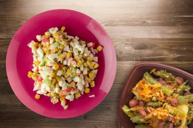 Kırmızı tabakta sebze salatası manzaralı yengeç salatası. Kahverengi ahşap arka planda yengeç salatası