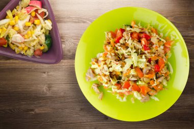 Tavuk mideli salata ile sebze havuç, soğan, biber, lahana, domates, brokoli. Kireç tabağında tavuk ve kahverengi ahşap arka planda salata. sağlıklı salatalar üst görünüm