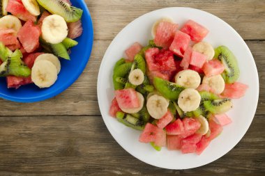 Kahverengi ahşap arka planda sağlıklı taze meyve salatası. .