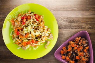 Tavuk mideli salata ile sebze havuç, soğan, biber, lahana, domates, brokoli. Kireç tabağında tavuk ve kahverengi ahşap arka planda salata. sağlıklı salatalar üst görünüm