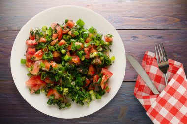 Çatal ve bıçak manzaralı vejetaryen yemekleri. Domates, soğan, beyaz tabakta rezene mor ahşap arka planda. sağlıklı yiyecekler