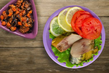 Mor tabakta tütsülenmiş uskumru. Sebze salatası manzaralı. Kahverengi ahşap arka planda limonlu uskumru ve domates.