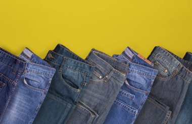 Kot pantolonlar sarı arkaplanda katlanmış, üst görünümde kopyalama çalışma alanı var.