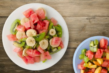 Kahverengi ahşap arka planda sağlıklı taze meyve salatası. .